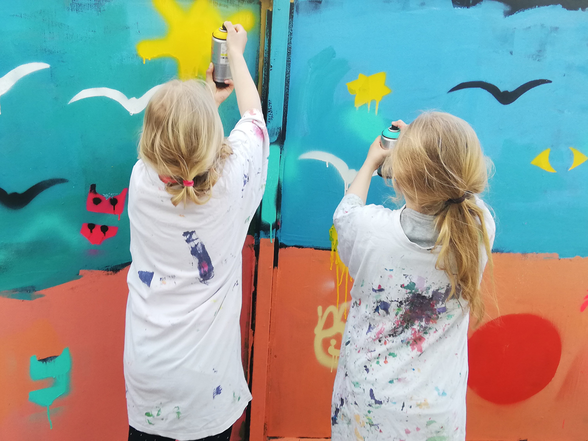 To piger maler med spraymaling i billedskolen på Willumsens Museum