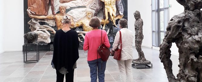 Tre kvinder står foran Willumsens monumentale værk, Det Store Relief, der er skabt af forskelligfarvet marmor.
