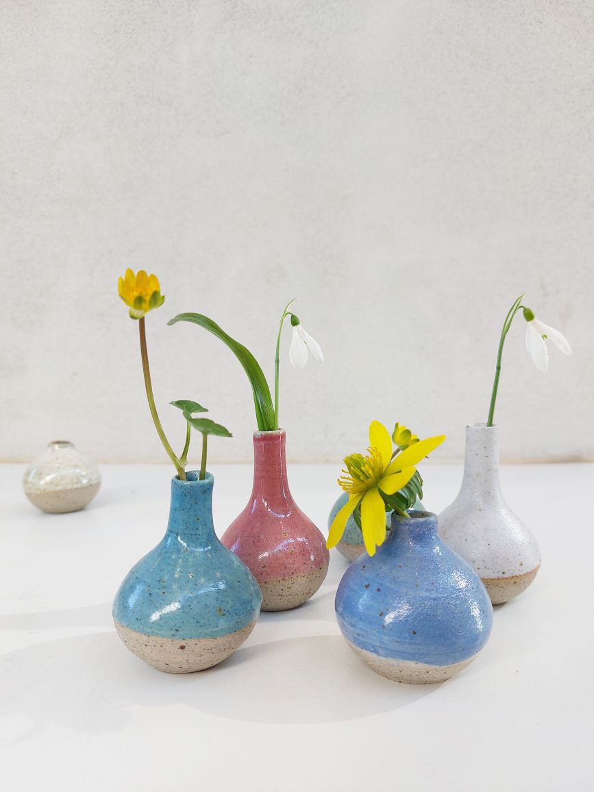 Fem miniaturevaser med forårsblomster